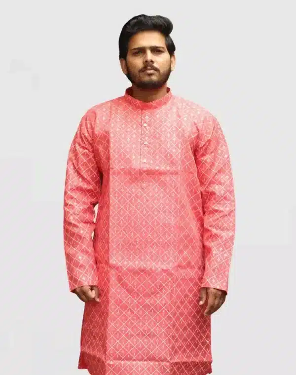 A man wearing a Coral Red or reddish-pink full-sleeve kurta with an all-over gold geometric print. Ideal for Diwali and Indian festivals.