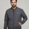 Men's Uton dark grey bomber jacket with ribbed trim and zip closure. Model is standing with his hand in the pocket.