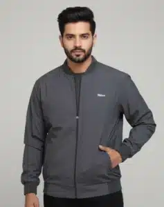 Men's Uton dark grey bomber jacket with ribbed trim and zip closure. Model is standing with his hand in the pocket.