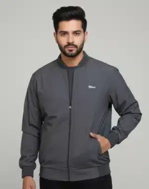 Men's Uton dark grey bomber jacket with ribbed trim and zip closure. Model is standing with his hand in the pocket.