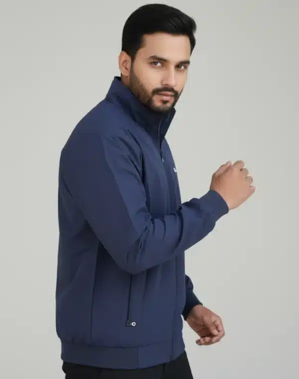 Male model wearing a Uton navy blue stand-collar jacket with a full zip. The jacket has small zip pockets on the side.